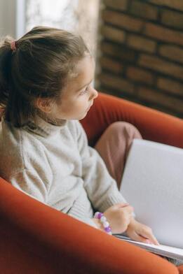 a little girl reading in braille